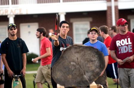 Riley Pope, sophomore media communications major, attempts the hatchet toss competition during the Great Outdoors residence life event.  - Photo by Amanda Rohde