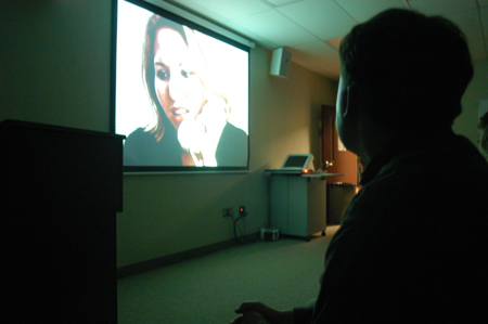Junior filmmaker Trae Cadenhead, digital media studies major, watches his film "Within a Room Somewhere" with a scholarship symposium crowd. - Photo by Kristen Nicole Sayres