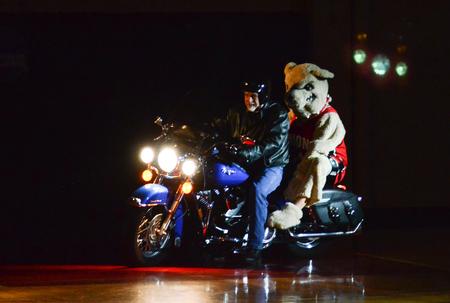 Buster the Bulldog rides through the Fred Delay Gymnasium on the back of a motorcycle at the beginning of Bulldog Madness. - Photo by Jacob Moore