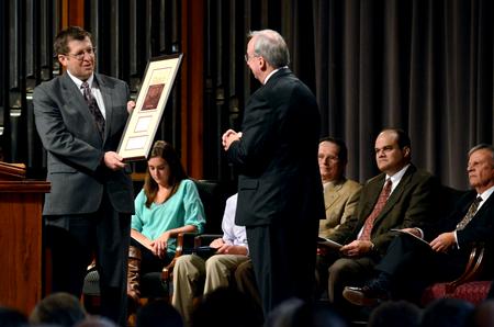 Ray Van Neste, director of the R.C. Ryan Center for Biblical Studies, presents David S. Dockery, president of the university, with a gift during a service of celebration and thanksgiving for Dockery and his wife, Lanese Dockery.  - Photo by Anne Richoux
