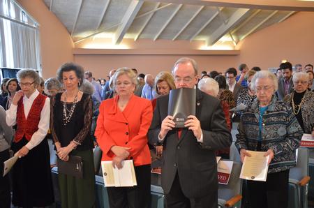 David and Lanese Dockery and friends bow their heads during prayer at the end of the celebration and thanksgiving service for the Dockerys. - Photo by Morris Abernathy