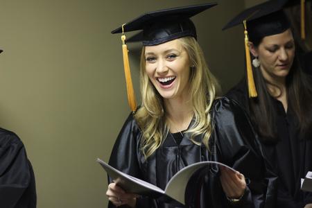 Abbey Stoker, nursing graduate, looks through the program while waiting for Fall Commencement Services to begin. - Photo by Matt McDaniel