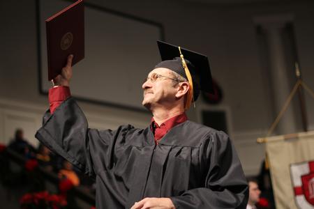 Richard Burroughs, nursing graduate, raises his diploma up to his family after receiving it during the Fall Commencement Services at West Jackson Baptist Church - Photo by Matt McDaniel