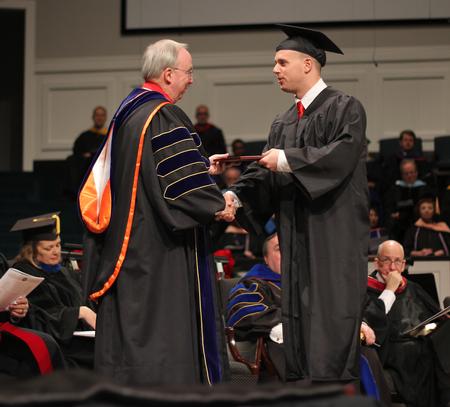 David S. Dockery, president of the university, presents Benjamin Fesmire, business administration graduate, with his diploma during Fall Commencement Services. - Photo by Matt McDaniel