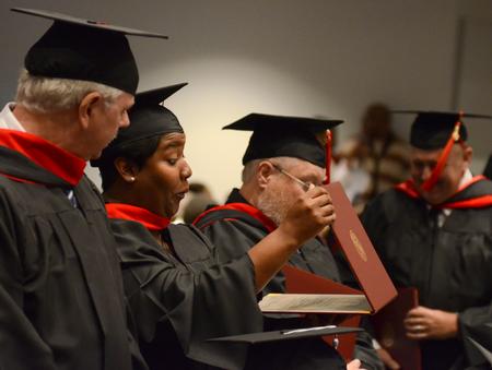 Angela Franklin, masters of Christian studies graduate, looks at her diploma for the first time during Fall Commencement Services. - Photo by Jacob Moore