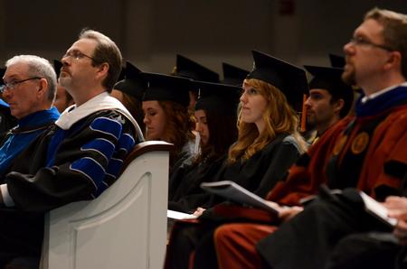 Olivia Wallace (center), Spanish graduate, listens during the commencement address. - Photo by Anne Richoux