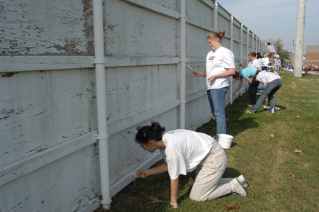 Students Stefani Martin and Kristen Merrill recondition the fence surrounding Union’s baseball field during Day of Remembrance 2003. - Photo by Kristen Nicole Sayres