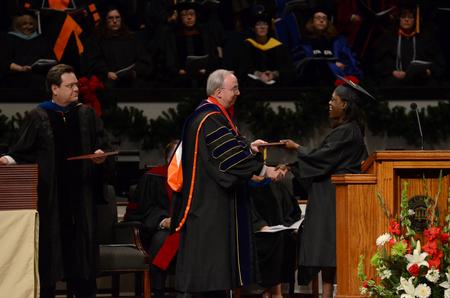 Latoya Chapman, social work graduate, receives her diploma from David Dockery, president of the university, during Fall Commencement Services. - Photo by Anne Richoux