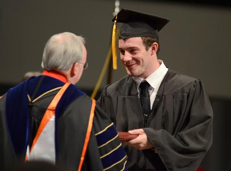 Tom Drury, mechanical engineering graduate, receives his diploma  during Fall Commencement Services at West Jackson Baptist Church. - Photo by Jacob Moore