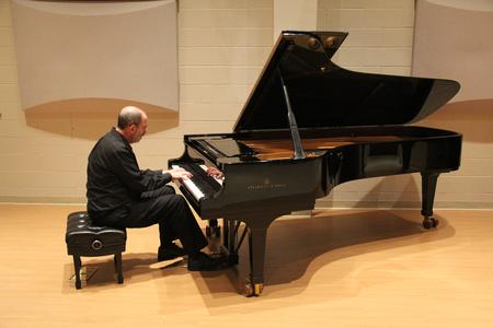 Terry McRoberts, university professor of music, performs a piano piece during his faculty recital in Hartley Hall. - Photo by Matt McDaniel