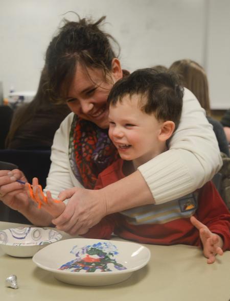 Ashley Jackson, resident director of the female quads, creates a memorable plate with her youngest son, Titus, to support World Vision International at Residence Life's Mugs & Kisses event in the Bowld Student Commons. - Photo by MiKalla Cotton