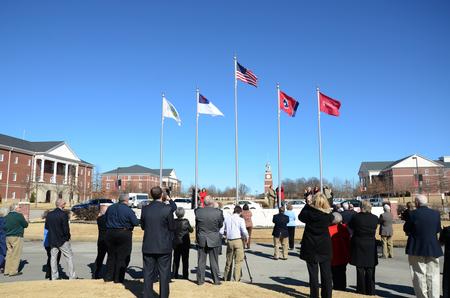Flags donated by the 1963 Graduating Class are raised for the first time at the campus entrance during Homecoming. - Photo by Amanda Rohde