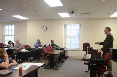 Graduate students listen as Justin Barnard, associate dean of the Institute for Intellectual Discipleship and associate professor of philosophy, teaches Introduction to Christian Ethics in Jennings Hall.  - Photo by Anne Richoux