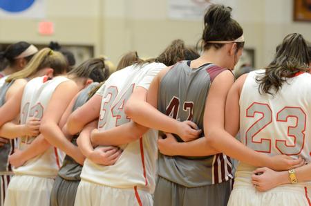 The Lady Bulldogs pray with the Lee University women's basketball team following their game in the Fred DeLay Gymnasium.  - Photo by Anne Richoux