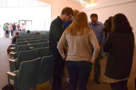 Staff pray with students planning to do missions this summer after the GO Trip report chapel service. - Photo by MiKalla Cotton