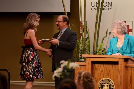 Scott Huelin, director of the honors community, congratulates Tori Brooks, senior English major, as a part of a banquet for honors students.  - Photo by Anne Richoux