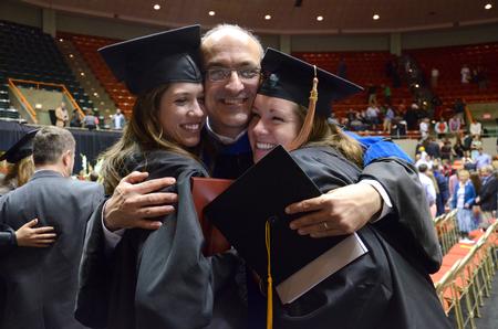 George Guthrie, Benjamin W. Perry Professor of Bible, hugs students Gracie Wise, english and history graduate, and Rachel Clardy, business administration graduate, following the Spring Commencement Services. - Photo by MiKalla Cotton