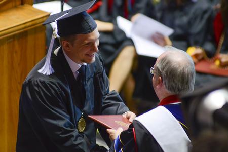 Zac Calvert, one of two intercultural studies graduates, receives his diploma from David S. Dockery at Spring Commencement Services. - Photo by Meg Rushing