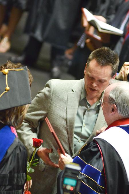 David S. Dockery and Carla Sanderson award the parents of music education graduate Olivia Greenlee her degree posthumously during Spring Commencement. - Photo by Emily Stookey