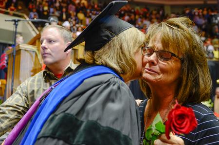 Carla Sanderson presents the parents of Leighton Williams a rose along with her posthumous diploma during Spring Commencement. - Photo by Kathleen Murray