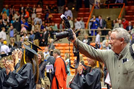 Morris Abernathy, staff photographer, works on documenting the class of 630 graduates at Union University’s 189th Spring Commencement, held at Oman Arena.  - Photo by Kathleen Murray