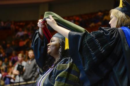 Carmen Owens is awarded a doctor of pharmacy hood by Carla Sanderson during Spring Commencement Services. - Photo by Kathleen Murray