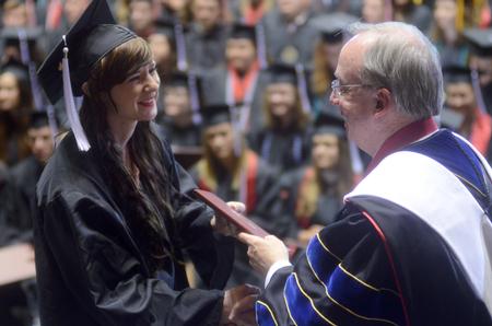 Kathryn Buncik, art graduate, receives diploma from David S. Dockery, president of the university, during Spring Commencement at the Oman Arena. - Photo by Amanda Rohde