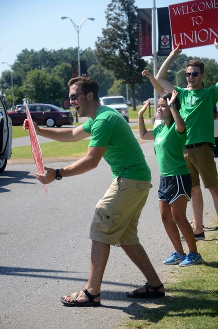 Ian Walker, senior business major and Life Group leader, enthusiastically greets new students on move-in day. - Photo by Meg Rushing