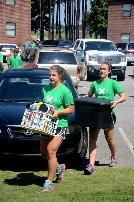 Life Group leaders Rebecca Shamblin, sophomore business major, and Hannah Small, senior biology major, help move new students into their rooms on move-in day.
 - Photo by Meg Rushing
