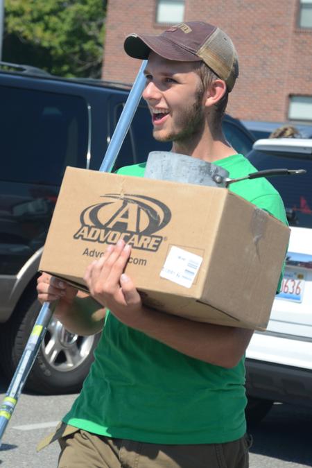 Life Group leader Joshua Edgren, junior physics major, helps bring boxes from new students' cars to their rooms. - Photo by Emily Stookey