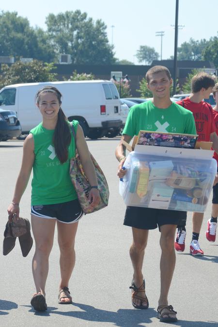 Life Group leaders Morgan Morfe, junior psychology major, and Nick Fleming, senior Christian ministry and missions major, help new students carry their belongings to their rooms. - Photo by Emily Stookey