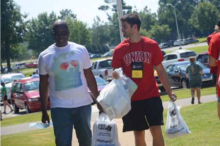 Focus leader Caleb Thompson (right), senior Biblical studies major, helps families move their children into their new rooms on move-in day. - Photo by Emily Stookey