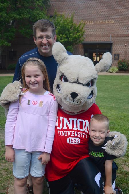 Ray Van Neste, professor of Biblical studies, and his children, Abigail and Timothy, pose with Buster the Bulldog for a photo during the move-in day. - Photo by Emily Stookey