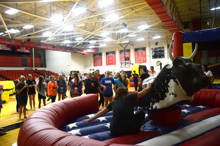 New students watch as a fellow freshman takes on the mechanical bull at the SAC Focus Fest in the Fred DeLay Gymnasium. - Photo by Meg Rushing