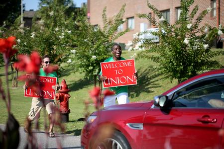 Life Group leaders hold signs welcoming new students and their families to Union University. - Photo by Kristi McMurry Woody