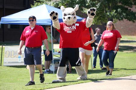 Josh Clarke, director of alumni services, walks with Buster the Bulldog around the residence complexes to help new students move in. - Photo by Kristi McMurry Woody