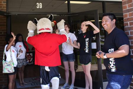 Buster the Bulldog high-fives MOSAIC members outside the gym during new student move-in day. - Photo by Kristi McMurry Woody