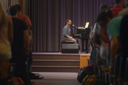 Cody Curtis, assistant resident director for the men's quads, leads students in a song during chapel. - Photo by Amanda Rohde