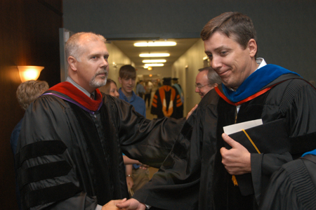 Department of chemistry chair Randy Johnston congratulates Faculty Member of the Year Kelvin Moore shortly after Awards Day. - Photo by Jim Veneman