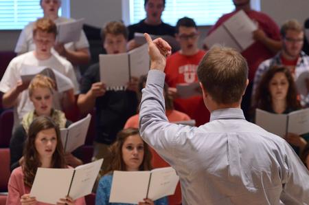 Chris Mathews, associate professor of music, rehearses with University Singers in Hartley Recital Hall. - Photo by MiKalla Cotton