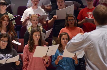 Chris Mathews, associate professor of music, rehearses with the University Singers in Hartley Recital Hall. - Photo by MiKalla Cotton