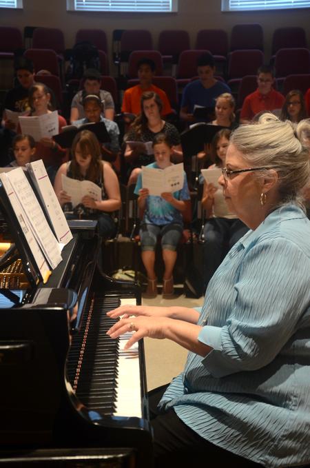 Deb Rhodes, adjunct music professor, accompanies a community student choir practice in Harley Recital Hall. - Photo by Meg Rushing