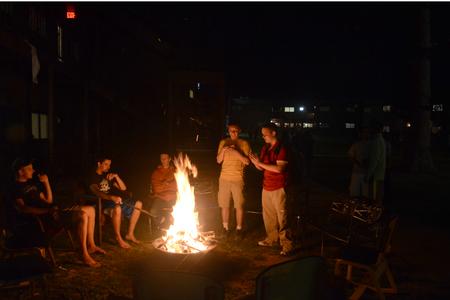 Students gather around the fire pit at Grey residence complex to warm up during Res Life's Progressive Snacking event. - Photo by Emily Stookey