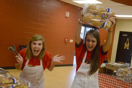 Maggie Robertson, junior nursing major, and Lindsey Chesak, junior math and secondary education major, excitedly await families coming to the Chi Omega fundraiser for the Make-A-Wish foundation.  - Photo by Emily Stookey