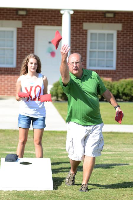 Mary Wayne, sophomore athletic training major, and her father, Trey Wayne, practice before the start of the corn hole tournament during Family Weekend. - Photo by Emily Stookey