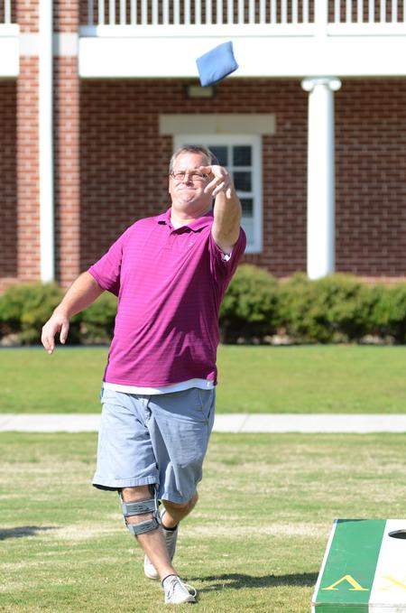 Union alum, Shawn Stookey, practices his throw before the corn hole tournament during Family Weekend. - Photo by Emily Stookey