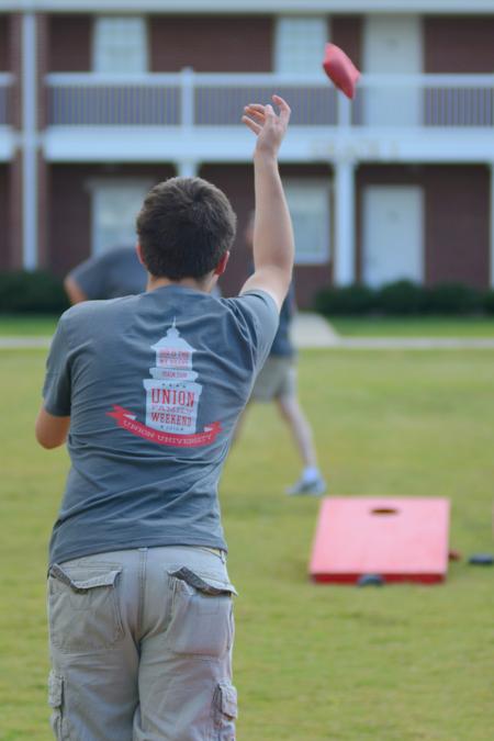 Blake Reeves, freshman Biblical studies major, gives a good toss during the Family Weekend corn hole tournament.  - Photo by Emily Stookey
