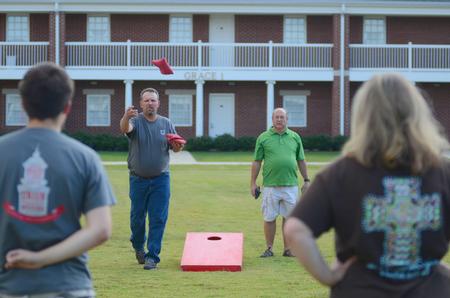 The Reeves family and the Wayne family compete against each other in Family Weekend's corn hole tournament.  - Photo by Emily Stookey