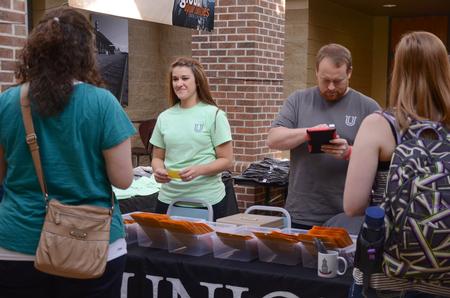Brittany Winfee, resident life secretary, and Ken Litscher, director of residence life, help parents gather their itineraries for Family Weekend.  - Photo by Amanda Rohde