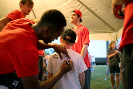 Members of the men's basketball team sign the t-shirt of a fan during Union Night.  - Photo by Kristi McMurry Woody